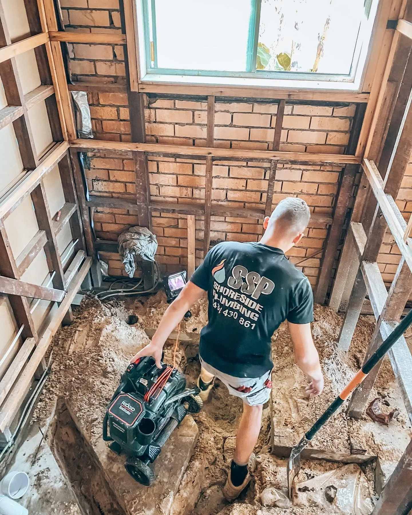 Plumber working under a raised house